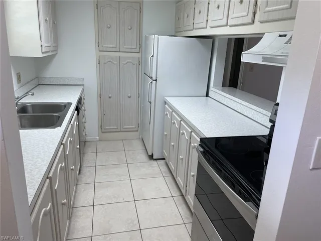 a kitchen with a refrigerator and cabinets