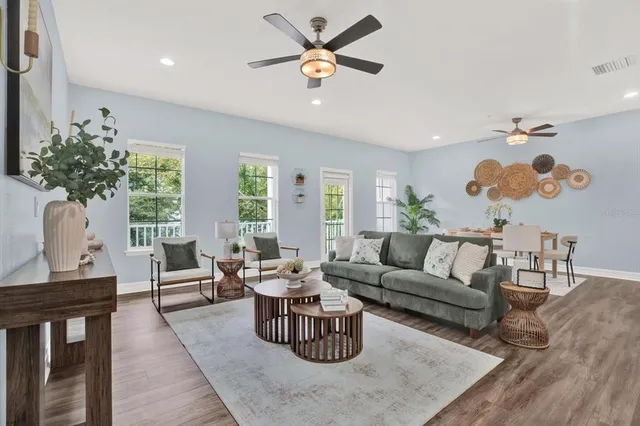 a living room with furniture two window and wooden floor