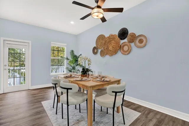 a kitchen with stainless steel appliances granite countertop a dining table chairs refrigerator and sink