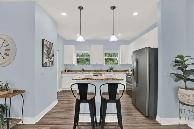 a kitchen with a stove a refrigerator and a wooden floor