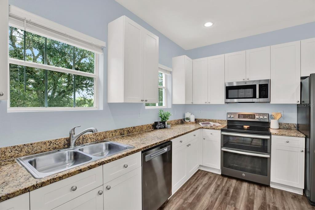 4529 Bay Spring Court Tampa, FL 33611 - Photo 20 of 66 a kitchen with granite countertop a sink stainless steel appliances and cabinets