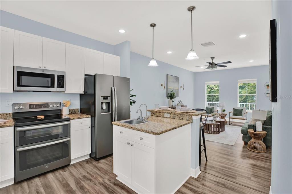 4529 Bay Spring Court Tampa, FL 33611 - Photo 21 of 66 a kitchen with a stove a refrigerator and a wooden floor