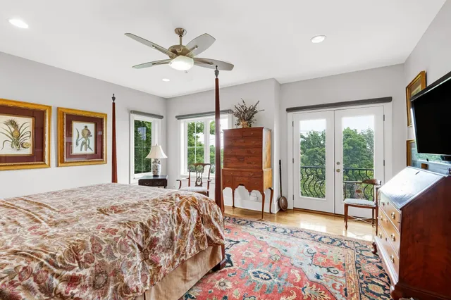 a bedroom with a bed television and a large window
