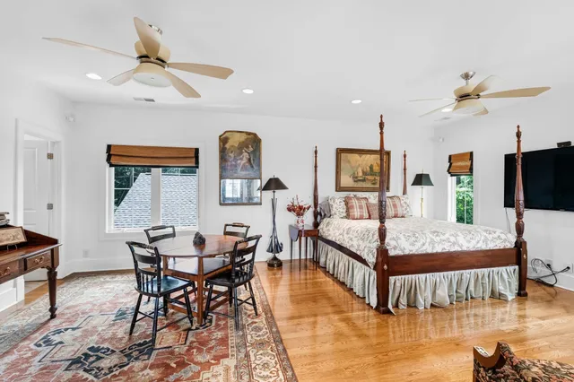 a dining room with wooden floor a chandelier fan a wooden floor and chandelier