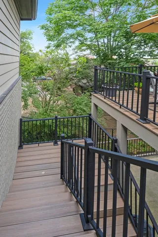 a balcony with wooden floor and yard in the back