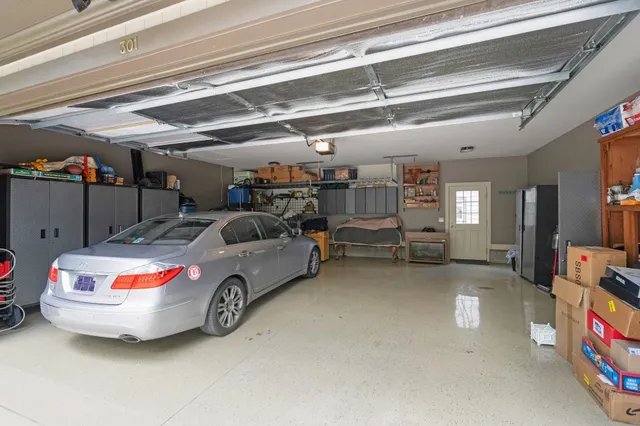 a view of a backyard with table and chairs potted plants and large tree