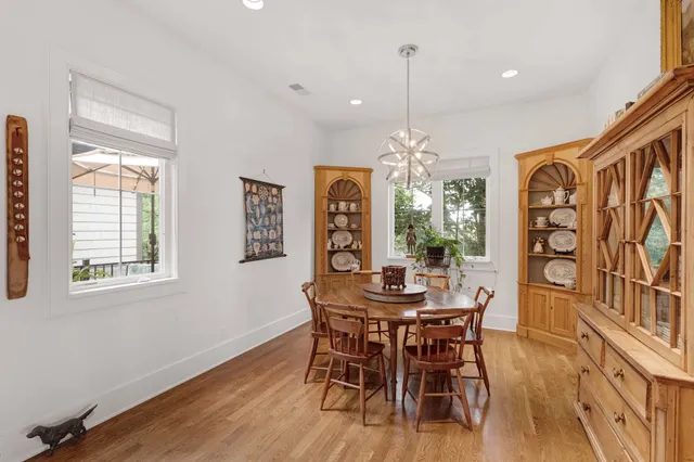 a dining room with furniture a chandelier and wooden floor