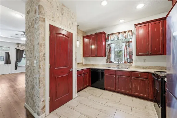 a large kitchen with stainless steel appliances granite countertop a refrigerator and a sink