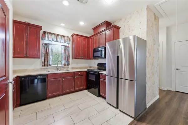 a kitchen with stainless steel appliances granite countertop a refrigerator and a sink