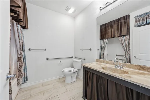 a bathroom with a granite countertop sink toilet and shower