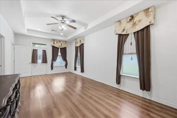 a view of a hallway with wooden floor and staircase