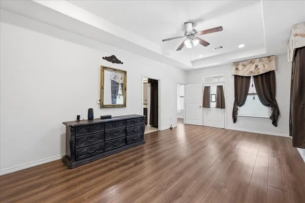 a view of a livingroom with wooden floor and a ceiling fan