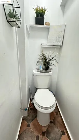a white toilet sitting next to a shower