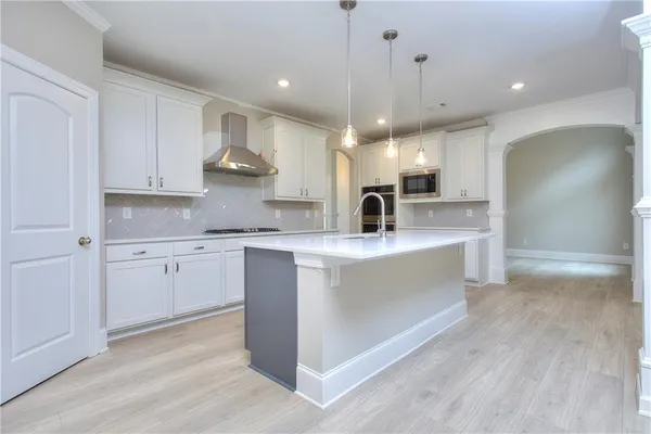 a kitchen with kitchen island a sink stainless steel appliances and cabinets