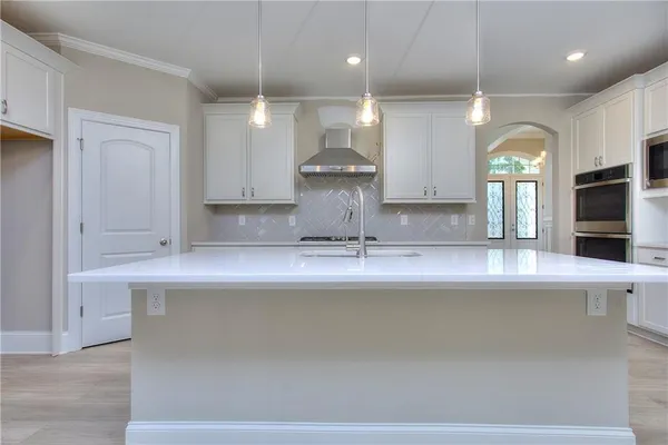 a kitchen with a sink a counter top space stainless steel appliances and a large window