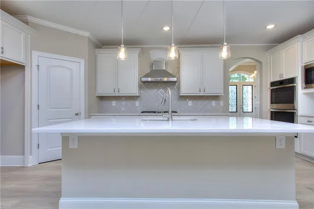 a kitchen with a sink a counter top space stainless steel appliances and a large window