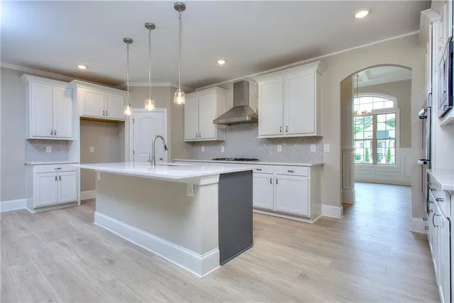 a large kitchen with kitchen island a sink stainless steel appliances and cabinets