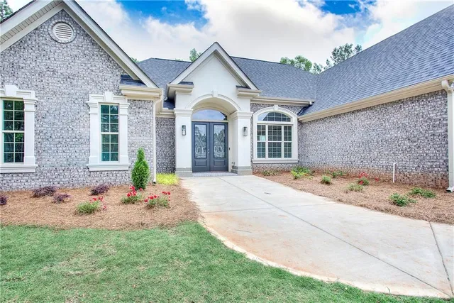 an empty room with wooden floor chandelier and windows
