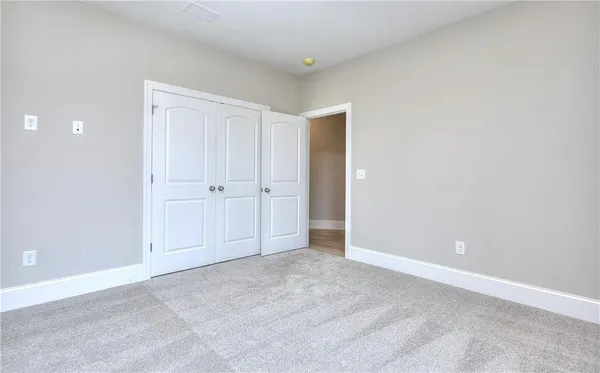 a view of an empty room with window and closet area