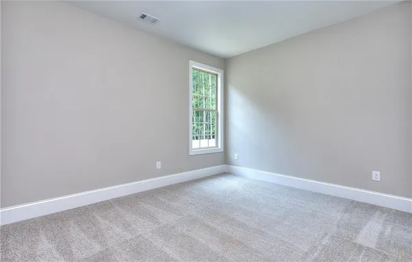 a view of an empty room with a fireplace and windows