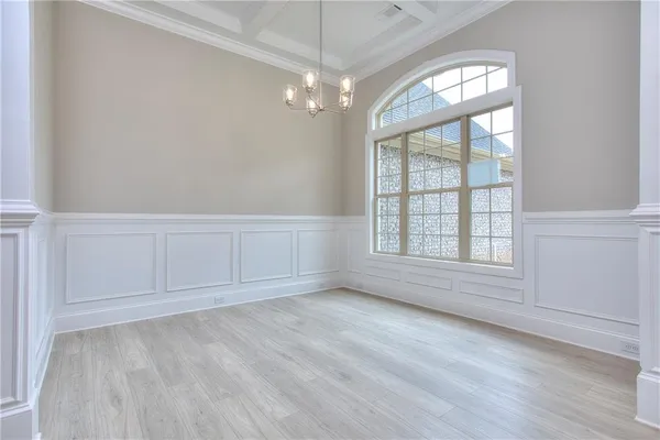 wooden floor in an empty room with a chandelier