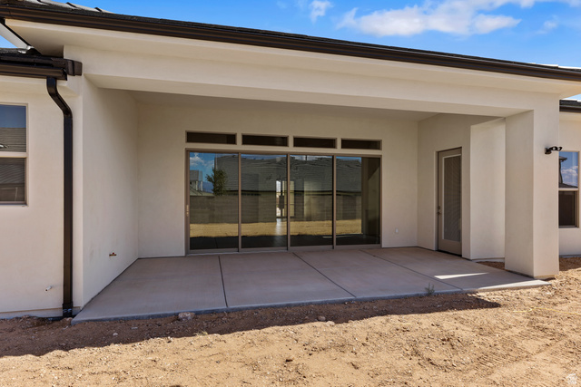 2955 East Rimrunner Drive St. George, UT 84790 - Photo 28 of 35 Covered concrete patio with sliding glass doors and transom windows