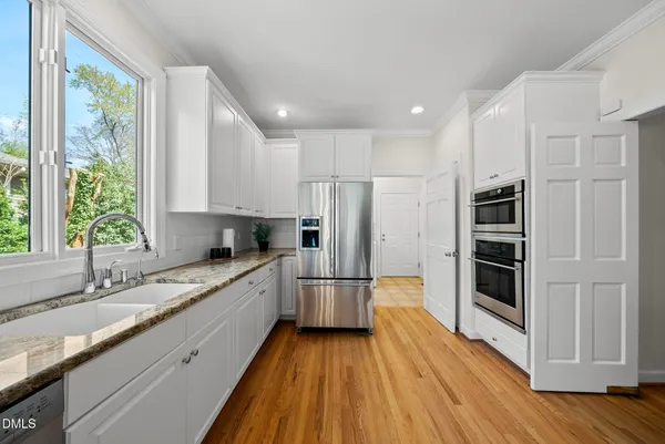 a kitchen with stainless steel appliances granite countertop a refrigerator and a sink