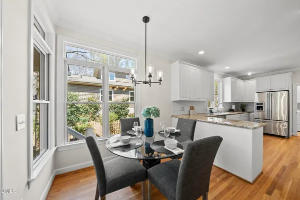 a dining room with furniture a chandelier and wooden floor