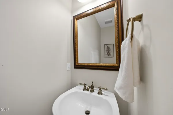 a bathroom with a sink and mirror with toilet