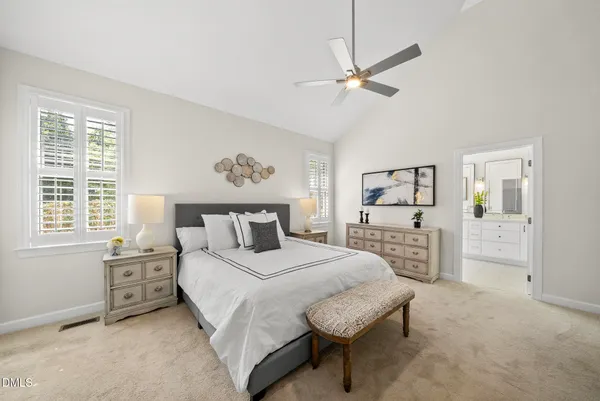 a bedroom with a large bed and a chandelier