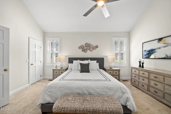 a bedroom with a bed a dresser and a painting