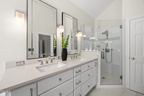 a bathroom with a double vanity sink shower and a mirror