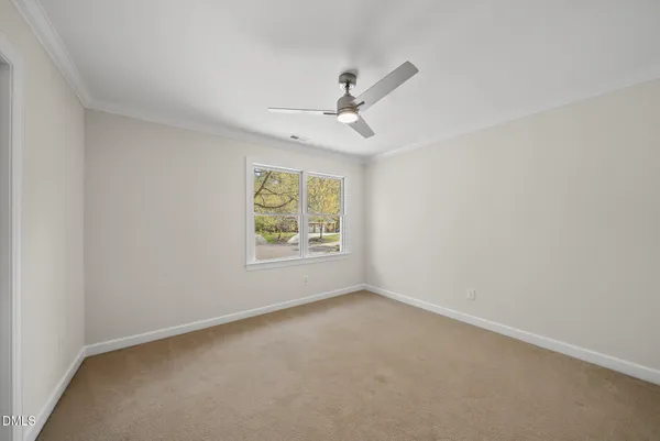 an empty room with a window and a fan
