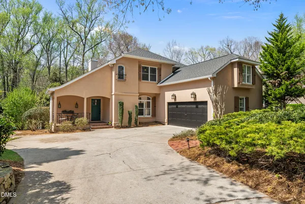 a view of a house with backyard and trees