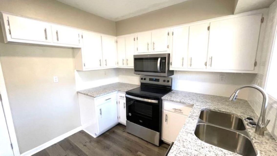 4704 Bill Knight Road Millington, TN 38053 - Photo 5 of 17 Kitchen featuring white cabinets, light stone counters, sink, and appliances with stainless steel finishes