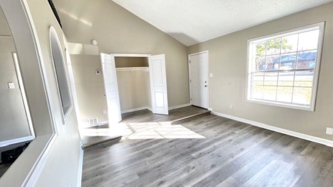 4704 Bill Knight Road Millington, TN 38053 - Photo 6 of 17 Unfurnished bedroom featuring a textured ceiling, light hardwood / wood-style flooring, and vaulted ceiling