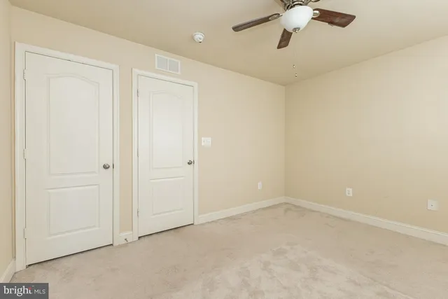 an empty room with a chandelier fan