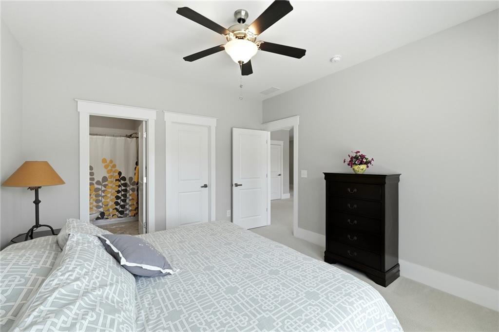 206 Trecastle Square Canton, GA 30114 - Photo 34 of 49 a bedroom with a bed and a lamp on dresser