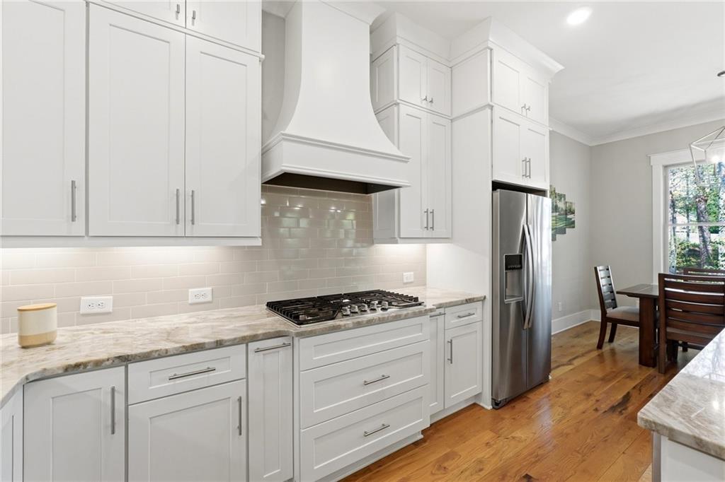 206 Trecastle Square Canton, GA 30114 - Photo 7 of 49 a kitchen with stainless steel appliances granite countertop a stove a refrigerator and a white cabinets with wooden floor