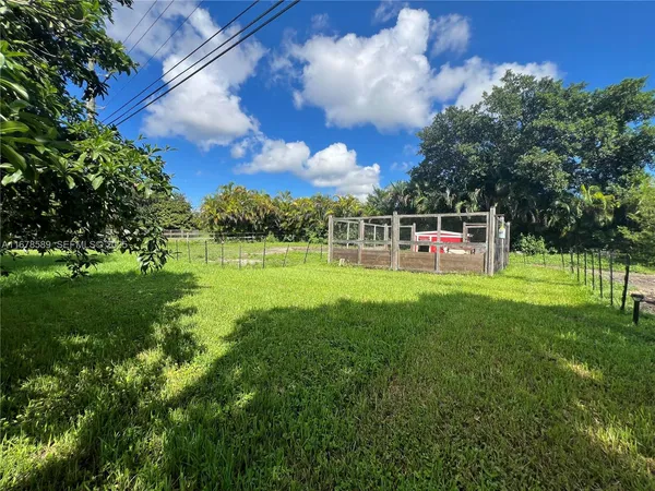 a view of a yard with a wooden fence