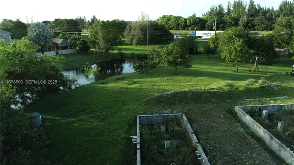 an aerial view of green landscape with trees houses and lake view