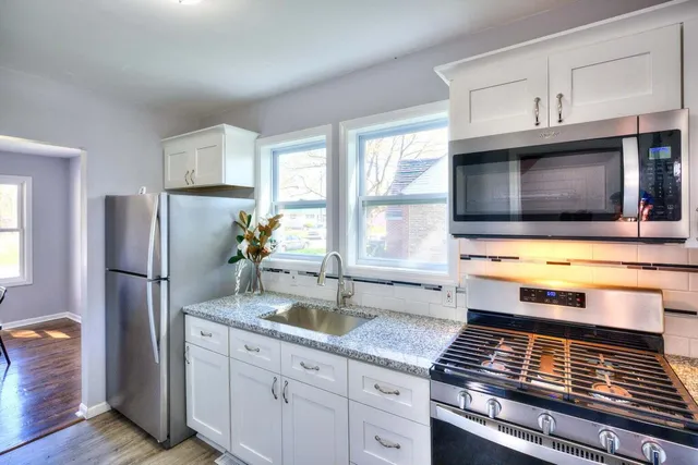 a kitchen with stainless steel appliances a stove microwave and refrigerator