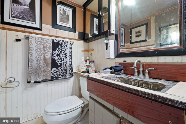 a bathroom with a granite countertop toilet sink and mirror