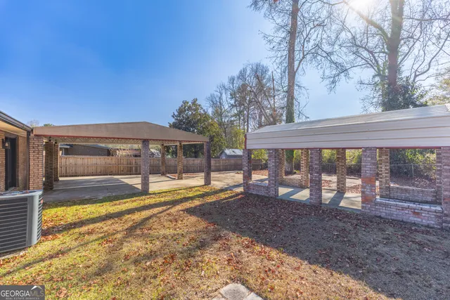a view of a house with backyard and sitting area