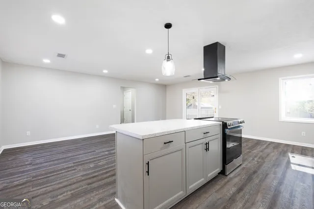 a kitchen with a sink stainless steel appliances and wooden floor