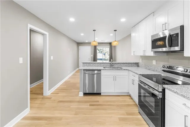 a kitchen with stainless steel appliances granite countertop a stove top oven a sink and a microwave