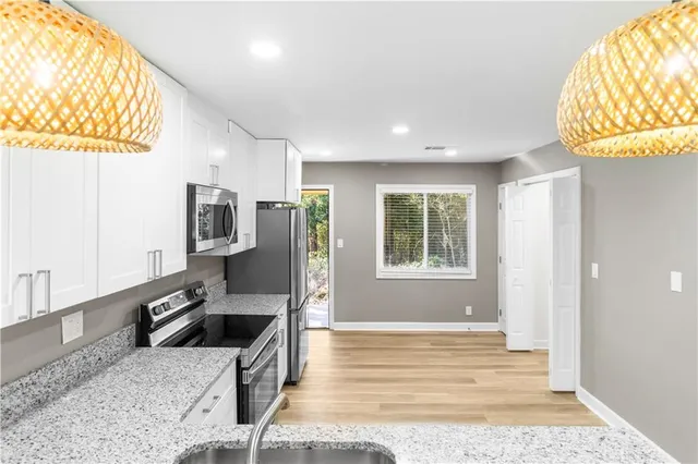 a kitchen with stainless steel appliances granite countertop a sink a stove and a wooden floors