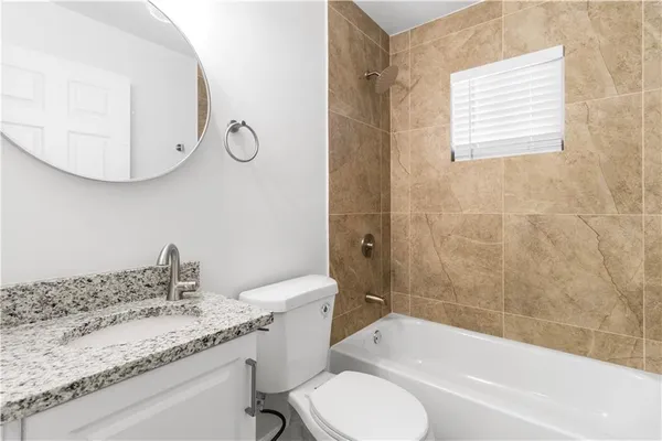 a bathroom with a granite countertop sink toilet and bathtub
