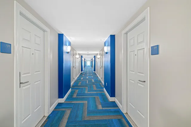 a hallway with wooden floor and staircase