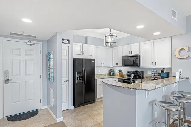 a kitchen with refrigerator a sink and white cabinets